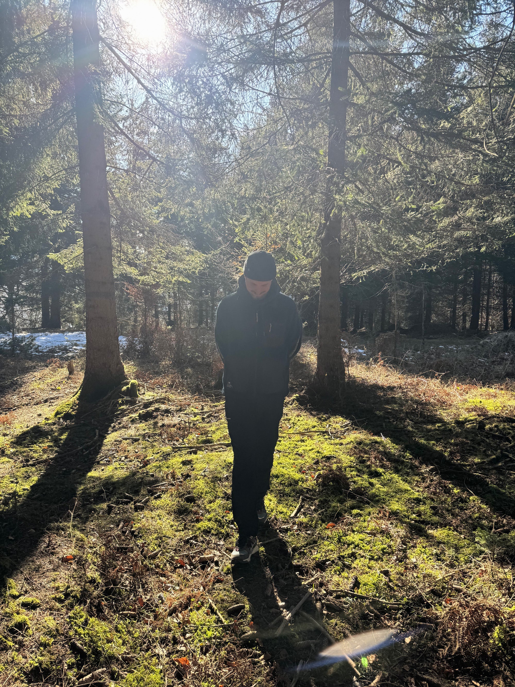 Mann im Wald in der Sonne beim Spaziergang